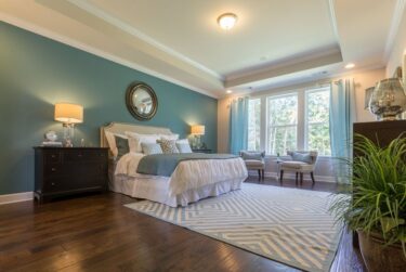 https://spec.imgix.net/uploads/images/_375xAUTO_crop_center-center_none/luxury-teal-master-bedroom-with-tray-ceiling-wood-floors-and-area-rug.jpg